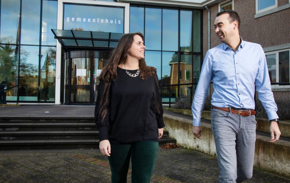 Collega's Jaap en Marlin lopen al pratend weg vanaf het gemeentehuis.